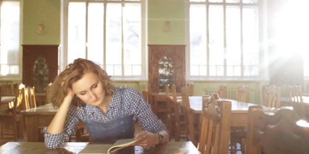 young woman with a book in the library