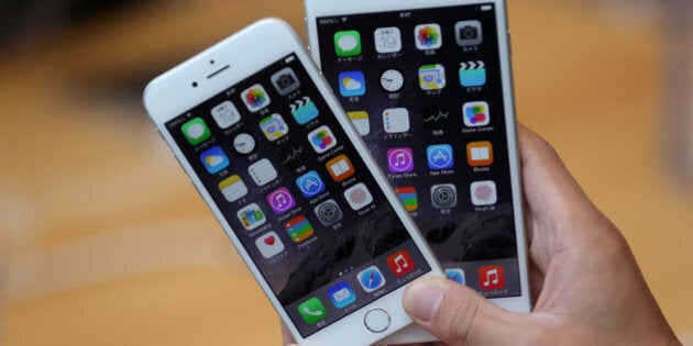 TOKYO, JAPAN - SEPTEMBER 19: A member of the press compares the new iPhone models at the launch of the new Apple iPhone 6 and iPhone 6 plus at the Apple Omotesando store on September 19, 2014 in Tokyo, Japan. On September 19, Apple's new products, iPhone 6 and iPhone 6 Plus, with iOS 8 featuring 4.7-inch and 5.5-inch displays, have become available in the US, Australia, Canada, France, Germany, Hong Kong, Japan, Puerto Rico, Singapore and the UK, and will be available in more than 20 additional countries beginning on September 26. (Photo by Chris McGrath/Getty Images)