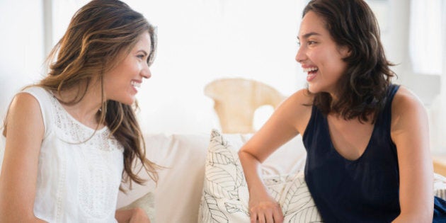 Hispanic women talking on sofa