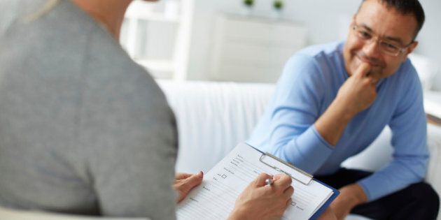 Female psychologist consulting mature man during psychological therapy session