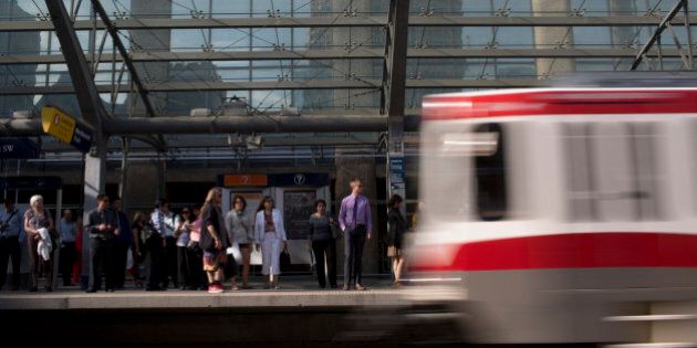 Commuters wait for a Calgary Light Rail Transit car in Calgary, Alberta, Canada, on Wednesday, Aug. 14, 2013. Statistics Canada (STCA) is scheduled to release June gross domestic product figures on Aug. 30. Photographer: Brent Lewin/Bloomberg via Getty Images