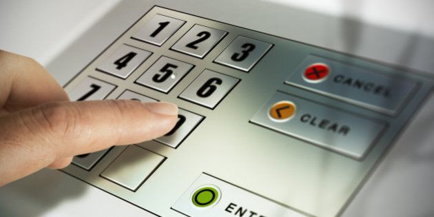 Finger about to press a pin code on a pad. Security code on an Automated Teller Machine, ATM