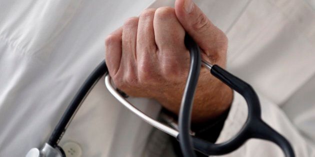 A photo illustration shows a French general practitioner holding a stethoscope in a doctor's office in Bordeaux January 7, 2015. French physicians protest against a new health reform bill that would introduce a third party payment system. Picture taken January 7, 2015. REUTERS/Regis Duvignau (FRANCE - Tags: HEALTH POLITICS)