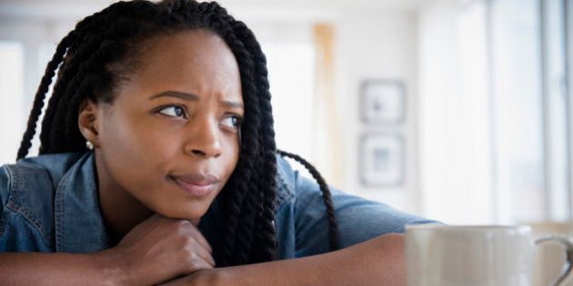Anxious Black woman resting chin on hands