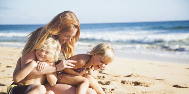 Mother with son (6-7) and daughter (2-3) on beach