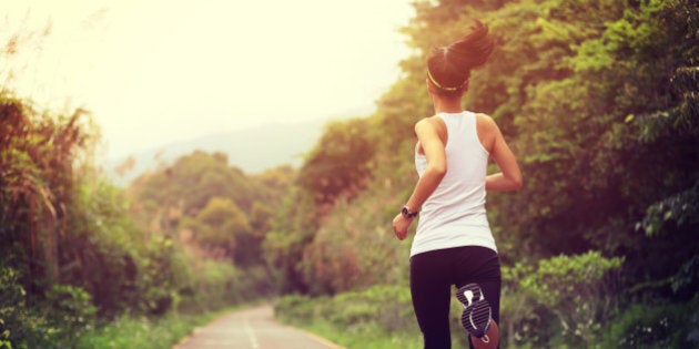 young fitness woman runner running at forest trail