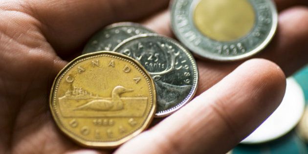 Some canadian dollar coins in a human hand