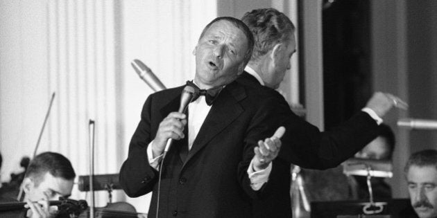 Singer Frank Sinatra belts out a song during an appearance at the White House, Washington, April 18, 1973. Sinatra, who retired from singing last year, returned to the stage for the first time as he sang 10 songs during the evening. He entertained during a state dinner honoring Italy's Prime Minister Giulio Andreotti. Behind Sinatra is bandleader Nelson Riddle. (AP Photo/Jim Palmer)