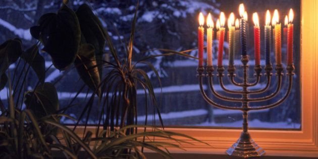 Lit menorah in window during Hanukkah