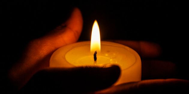 Hands holding a candle during a candle light vigil with copy space