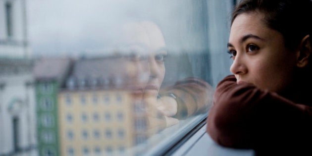 Teenager looking out of window, Munich, Germany