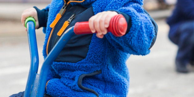 Boy looking away while riding tricycle on playground