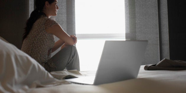 Sad woman looking out hotel window