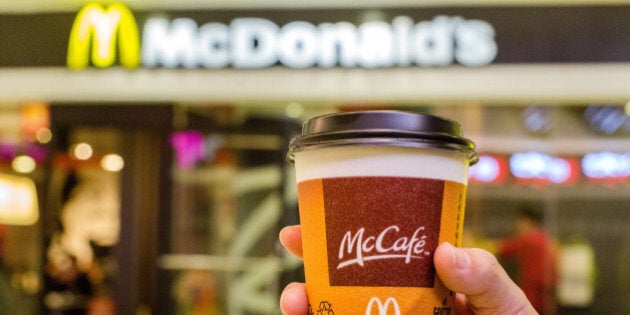 BEIJING, CHINA - 2015/01/28: A customer holds a cup of Coffee served by McCafe out of a McDonald's restaurant. In the 2014 fiscal figures released on January 23, 1% drop in global sales in 2014 highlighted the challenges McDonalds faced. Especially, weak economy in Russia and supplier issue In China drives down McDonald's revenue growth in 2014. (Photo by Zhang Peng/LightRocket via Getty Images)