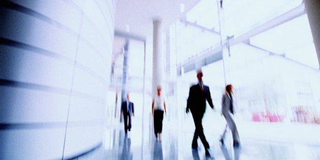 Business people in corridor of office building, (blurred motion)