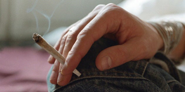 Hand holding smoking joint