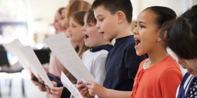 Group Of School Children Singing In Choir Together