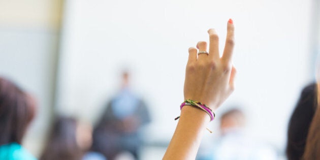 High school or college student raising hand to answer question