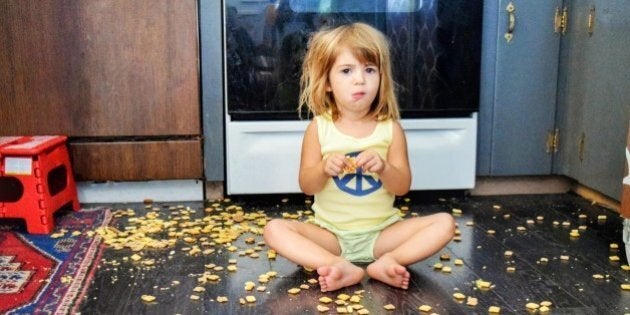 Toddler spills a snack all over the floor, but seems content to eat it anyways