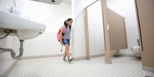 Eleven-year-old girl walks into school bathroom.