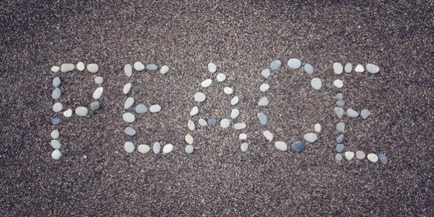 'Peace' word written with pebbles on the sand. Aged photo. 'Peace' word made by small stones on the beach. Word on the sand - toned photo. Antalya Province, Turkey. Wide photo for site slider.