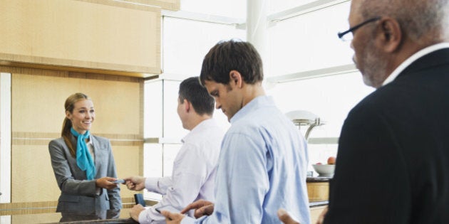 Business people in line at airport front desk