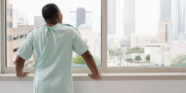 Black man wearing hospital gown in hospital