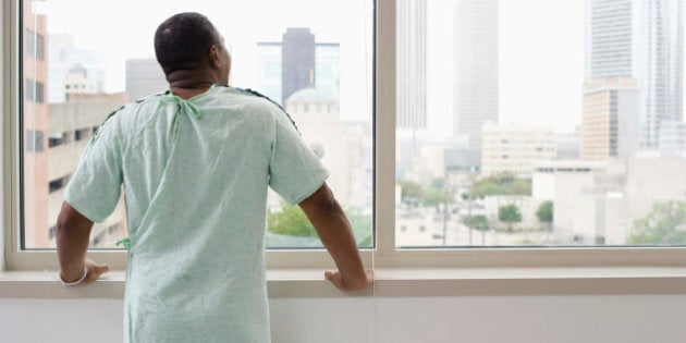 Black man wearing hospital gown in hospital