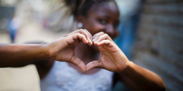 Beira, Mozambique - September 28: A girl formes a heart with her hands in a slum in the city area Beira on September 28, 2015 in Beira, Mozambique. (Photo by Thomas Trutschel/Photothek via Getty Images)