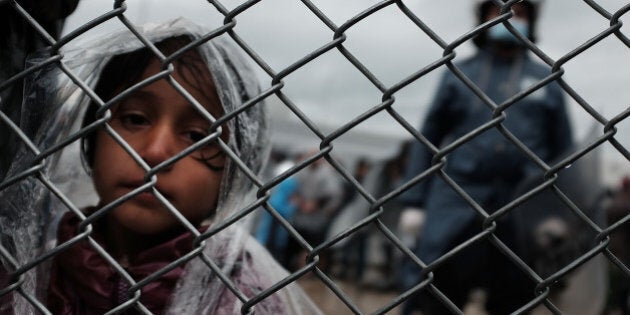 MITILINI, GREECE - OCTOBER 23: A child waits with her father at the migrant processing center at the increasingly overwhelmed Moria camp on the island of Lesbos on October 23, 2015 in Mytilene, Greece. Dozens of rafts and boats are still making the journey daily as thousands flee conflict in Iraq, Syria, Afghanistan and other countries. More than 500,000 migrants have entered Europe so far this year. Of that number four-fifths of have paid to be smuggled by sea to Greece from Turkey, the main transit route into the EU. Nearly all of those entering Greece on a boat from Turkey are from the war zones of Syria, Iraq and Afghanistan. (Photo by Spencer Platt/Getty Images)