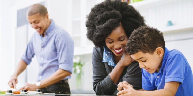 Mixed Race Family in the kitchen cooking and using digital tablet.