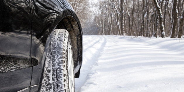 Driving SUV car in winter on forest road with much snow