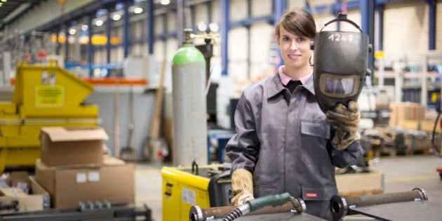 HERFORD, GERMANY - JULY 08: Female precision machinist with welding helmet in the production of Wemhoener Surface Technologies GmbH & Co KG on July 08, 2014, in Herford, Germany. Wemhoener Surface Technologies produces short-cycle presses for the laminate industry. (Photo by Ute Grabowsky/Photothek via Getty Images)***Local Caption***