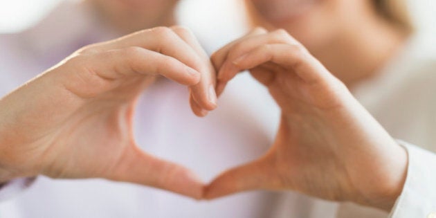 Couple making heart shape with hands