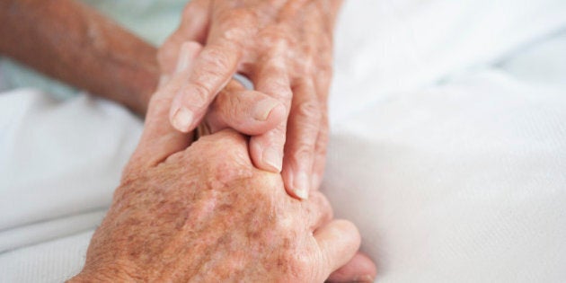 Husband comforting wife in hospital bed