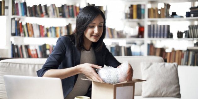 Woman preparing parcel for shipment in her cozy loft apartment