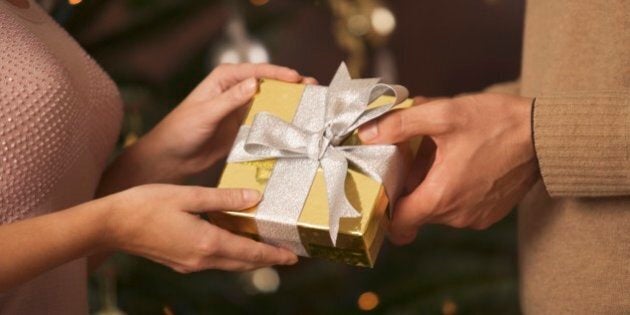 Woman giving man Christmas gift