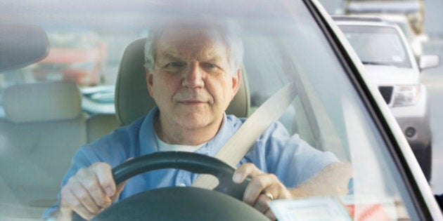 Elderly man driving car in traffic