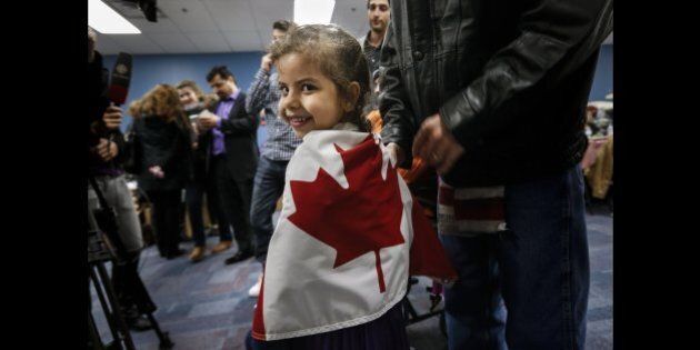 TORONTO, ON - DECEMBER 27: Reemas Al Abdullah, 5, wrapped herself in a Canadian flag prior to a dinner hosted by Friends of Syria at the Toronto Port Authority. (Richard Lautens/Toronto Star via Getty Images)