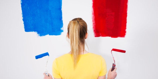 Young woman painting a wall