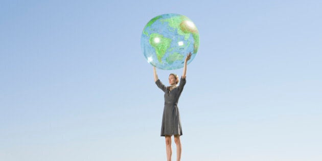 Businesswoman holding up globe