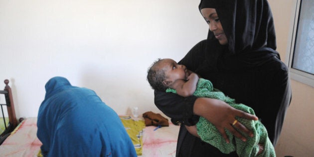 MOGADISHU, SO - MAY 4: Canadian Ilwad Elman holds a month-old-baby in the Elman Peace Center, a rape crisis shelter she runs with her mother. The organization was started by her father, who was slain by warlords in 1996. Ilwad returned to Mogadishu after growing up in Ottawa. The baby was born to a woman, whose identity is concealed in the background, who had been repeatedly raped by soldiers. (Michelle Shephard/Toronto Star via Getty Images)