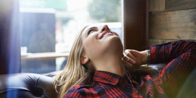 woman looking happy relaxing on sofa