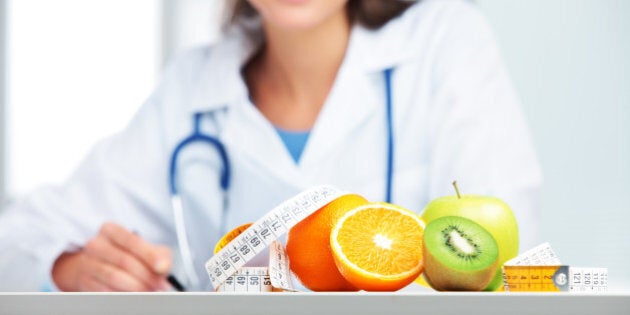 Nutritionist female Doctor in her office. Focus on fruit