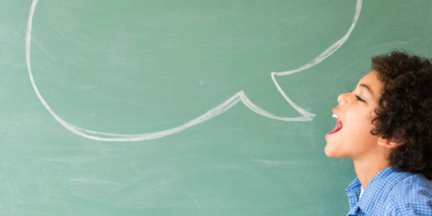 Mixed race boy shouting into speech bubble on chalkboard