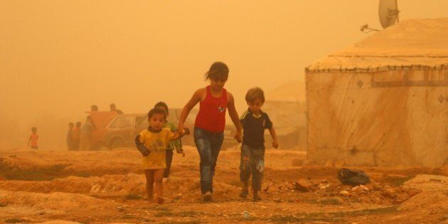 Syrian children walk amid the dust during a sandstorm on September 7, 2015 at a refugee camp on the outskirts of the eastern Lebanese city of Baalbek. AFP PHOTO / STR (Photo credit should read -/AFP/Getty Images)