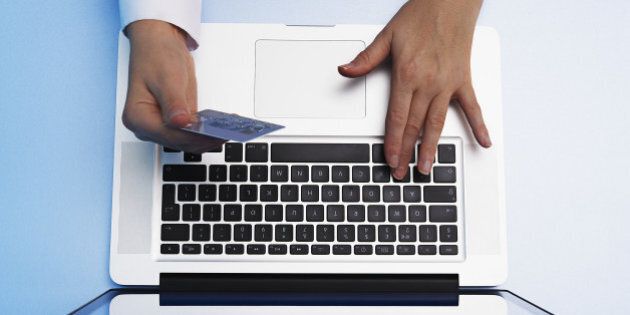 Close-up of hands using laptop and credit card.