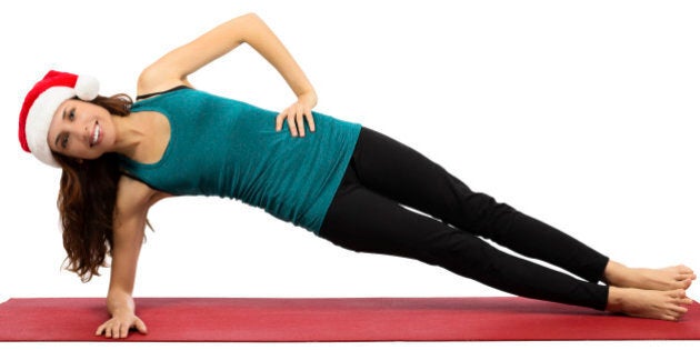 Attractive caucasian young christmas woman doing side plank pose in yoga