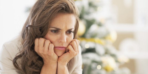 Portrait of frustrated young woman near christmas tree