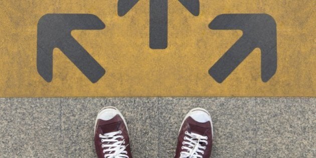 Pair of shoes standing on a road with three grey arrow on the yellow background